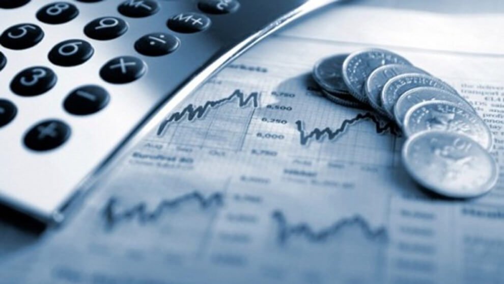 imagen de estadísticas de la economía, encima una calculadora y monedas