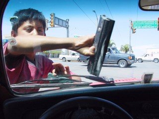 niño limpiando parabrisas de un carro