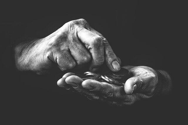 fotografía blanco y negro de unas manos con unas monedas