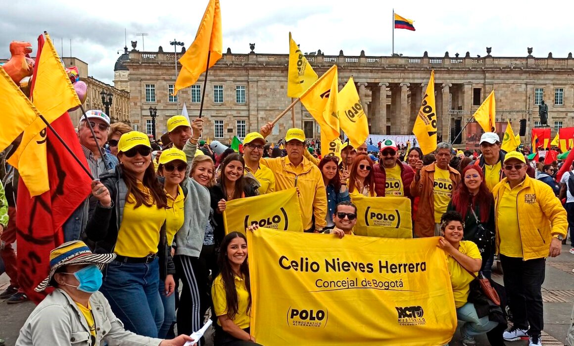 Concejal rodeado de personas con banderas y camisetas amarillas en la plaza de Bolivar